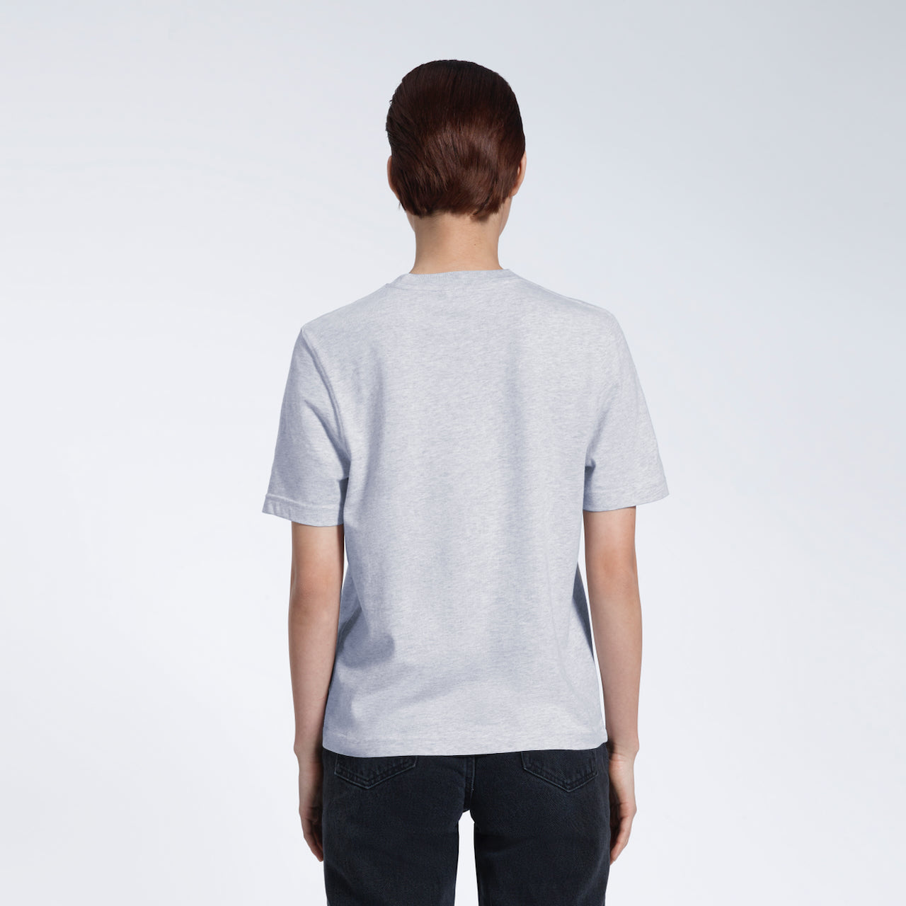 A woman with her back to the camera, modelling a plain grey short sleeve organic cotton t shirt.