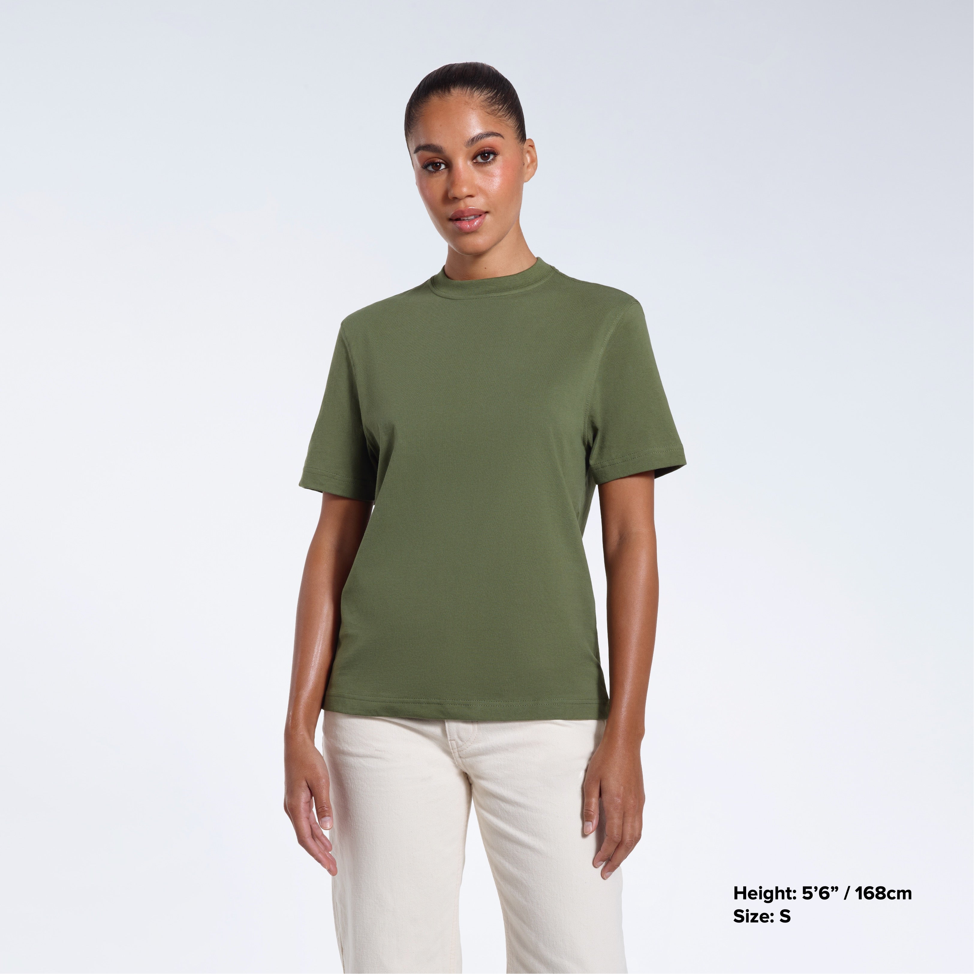 A woman facing front on looking at the camera, modelling a khaki green short sleeve organic cotton t shirt.