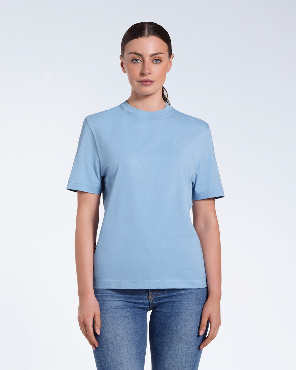 A woman facing front on looking at the camera, modelling a blue short sleeve organic cotton t shirt.