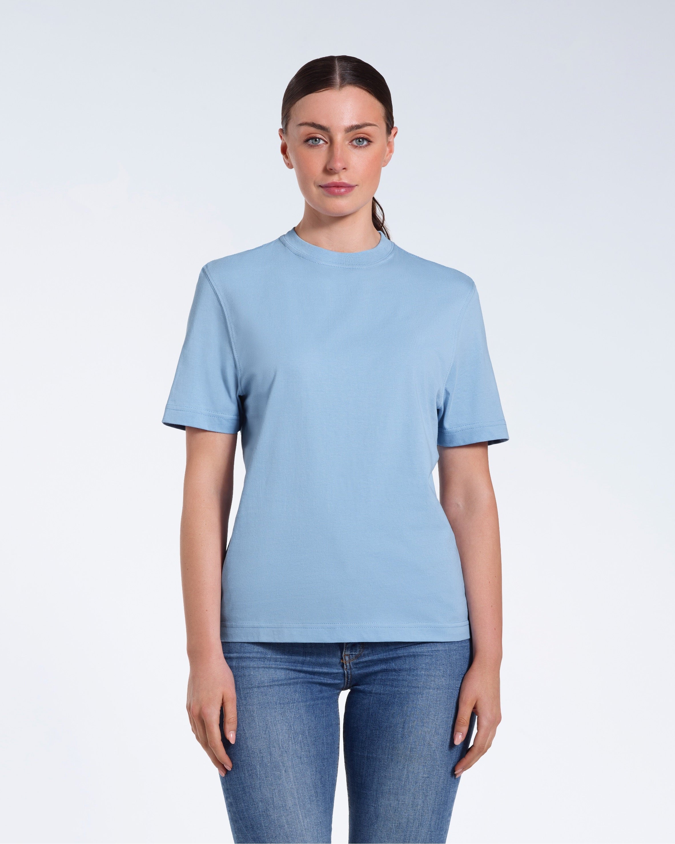 A woman facing front on looking at the camera, modelling a blue short sleeve organic cotton t shirt.