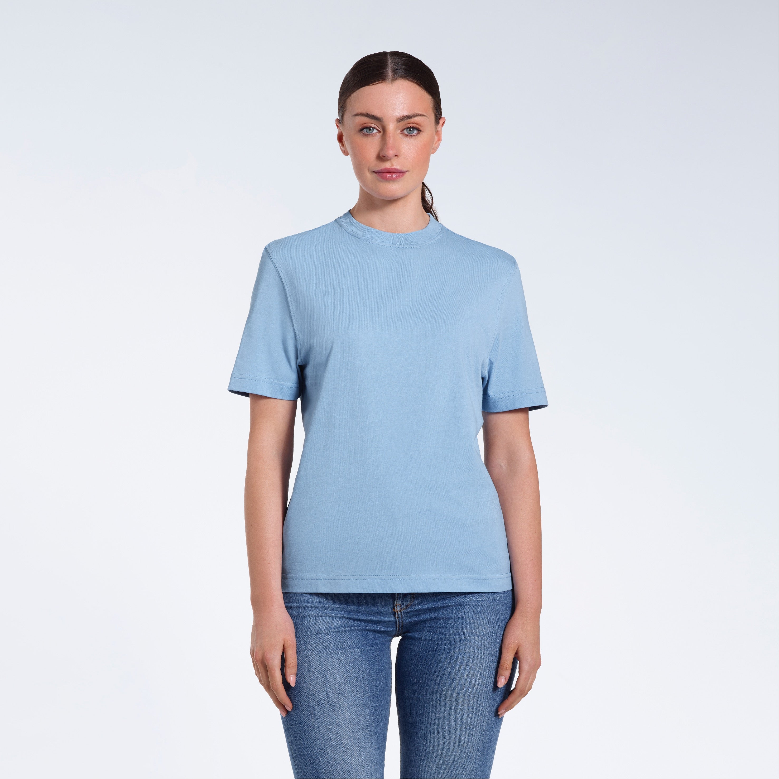 A woman facing front on looking at the camera, modelling a blue short sleeve organic cotton t shirt.