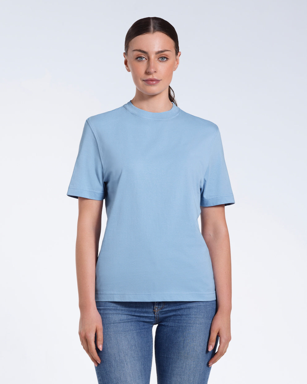 A woman facing front on looking at the camera, modelling a blue short sleeve organic cotton t shirt.