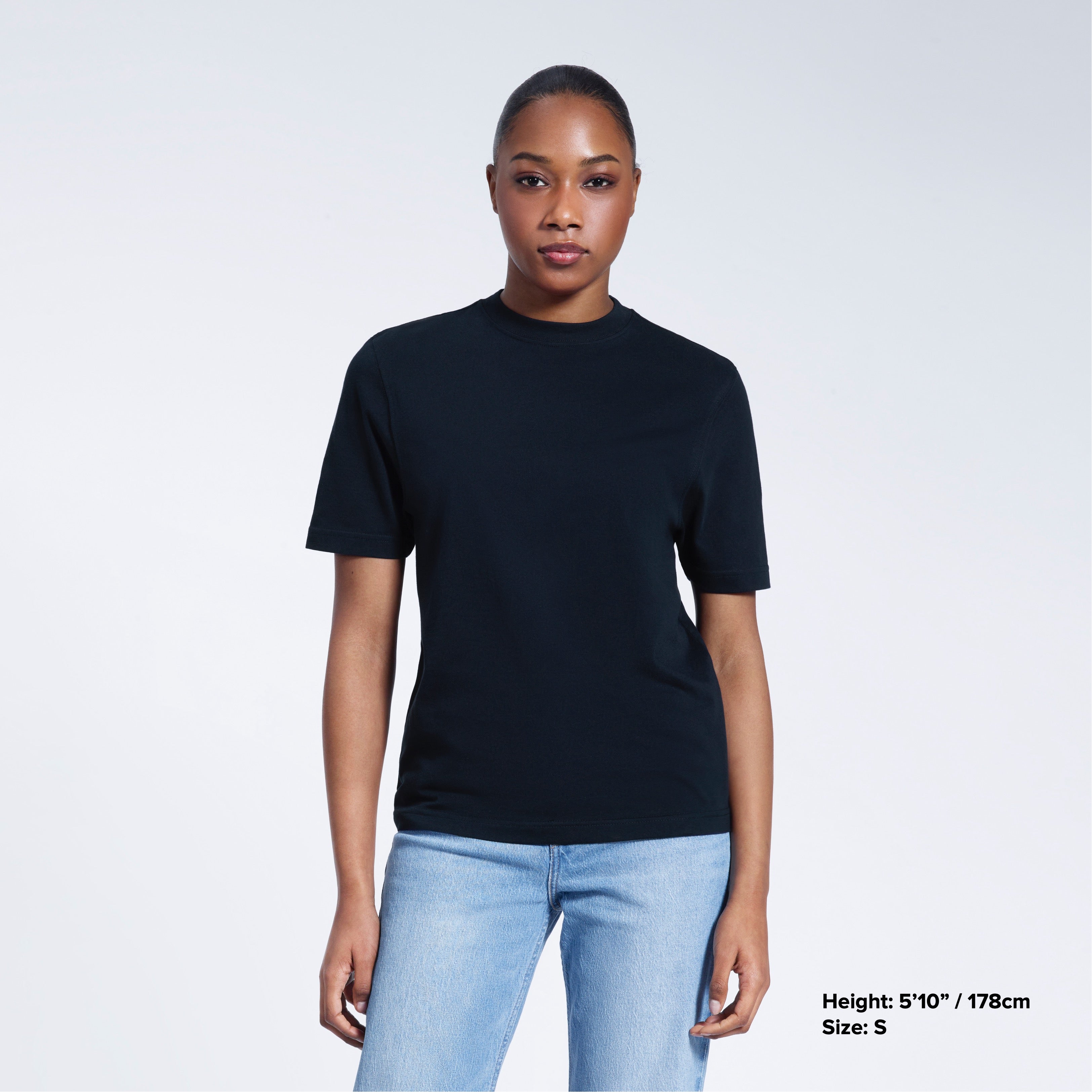 A woman facing front on looking at the camera, modelling a navy short sleeve organic cotton t shirt.