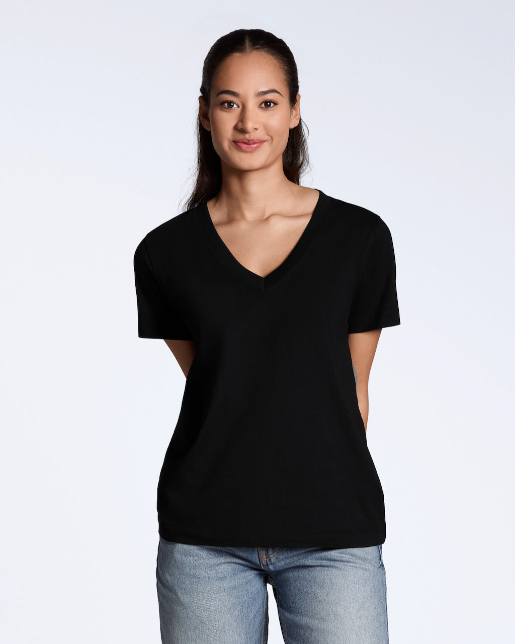 A woman smiling into the camera, modelling a plain black, organic cotton v neck t shirt.