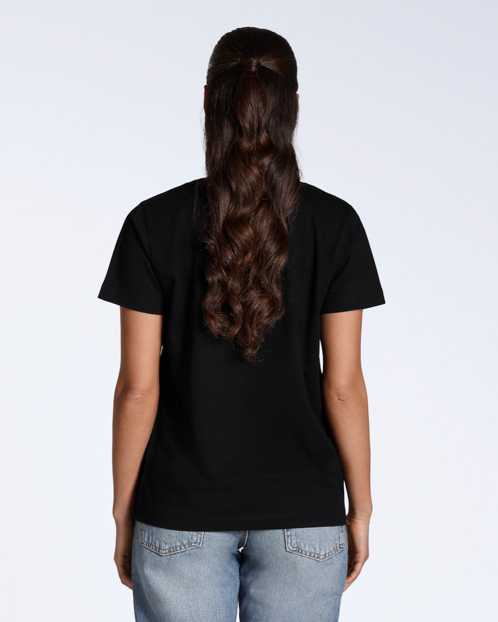 A woman facing away from the camera, modelling a plain black, organic cotton v neck t shirt.