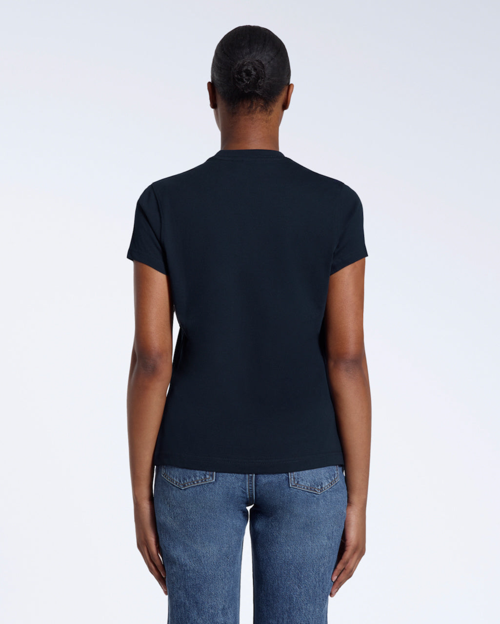 A woman with her back to the camera, modelling a plain navy short sleeve organic cotton t shirt.