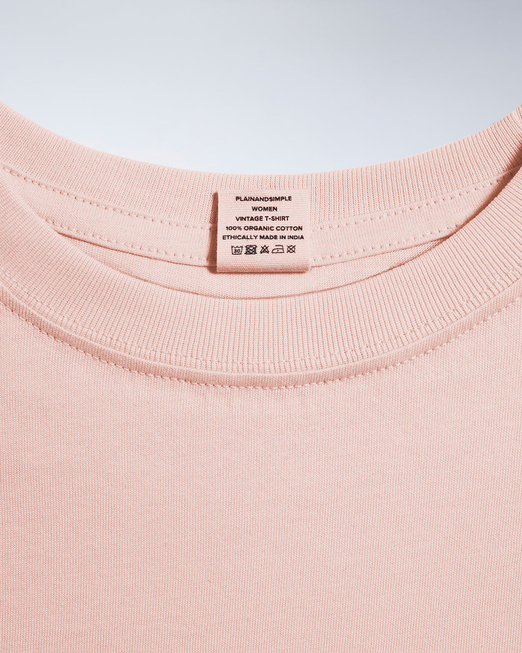 A close up of an neck label in a women's pink short sleeve crew neck organic cotton t shirt.