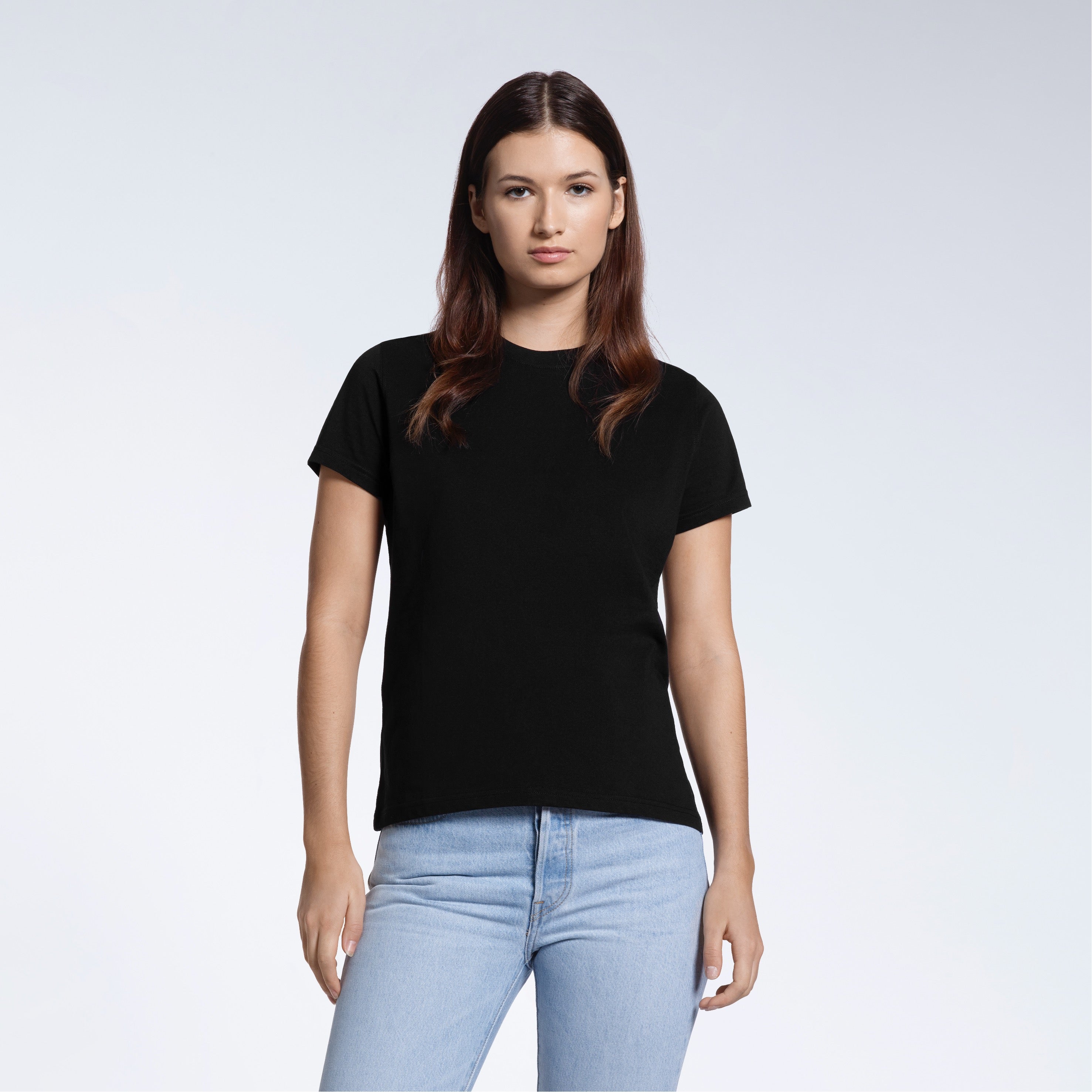A woman facing front on looking into the camera, modelling a plain black short sleeve organic cotton t shirt.