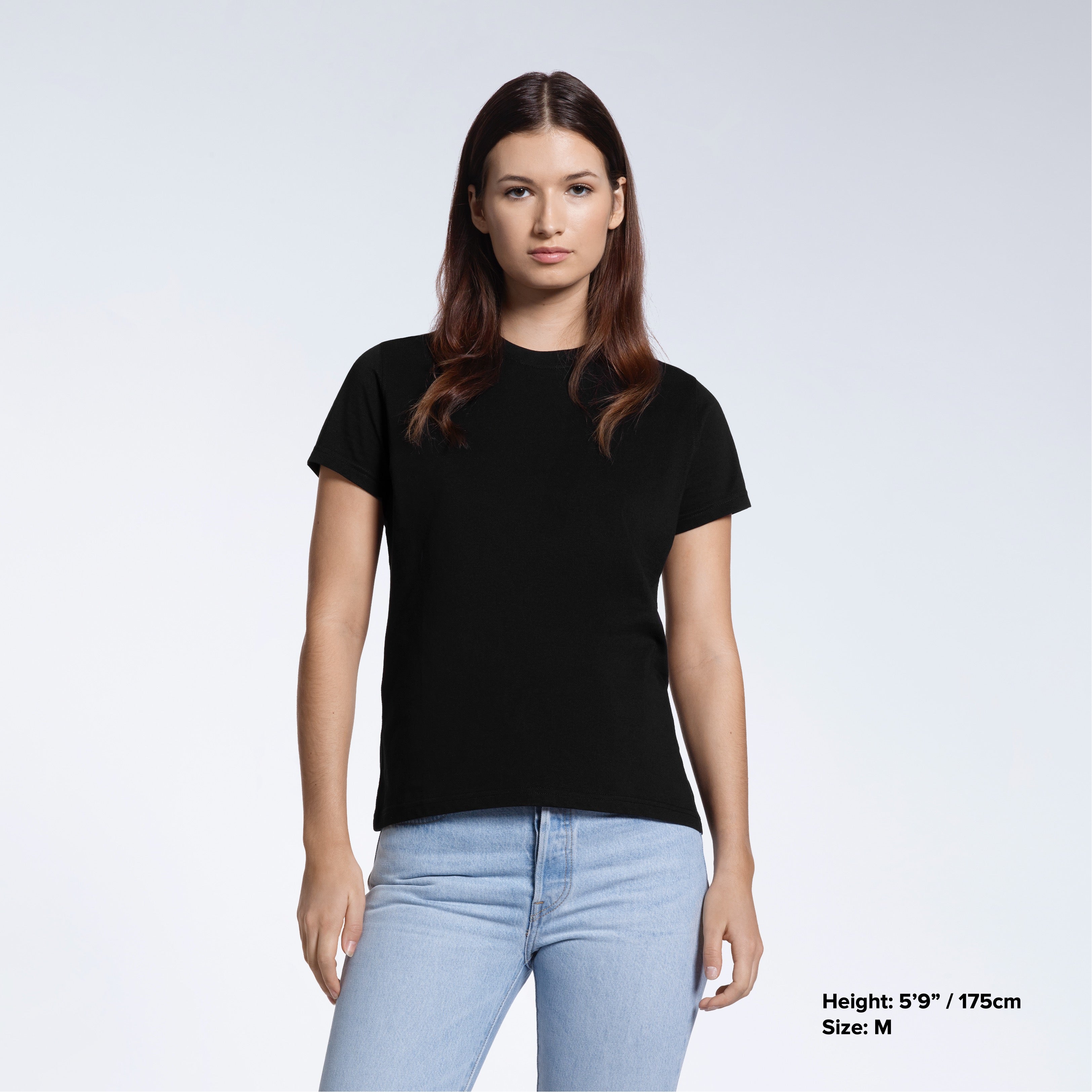 A woman facing front on looking into the camera, modelling a plain black short sleeve organic cotton t shirt.