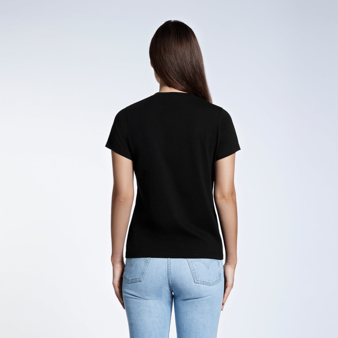 A woman with her back to the camera, modelling a plain black short sleeve organic cotton t shirt.