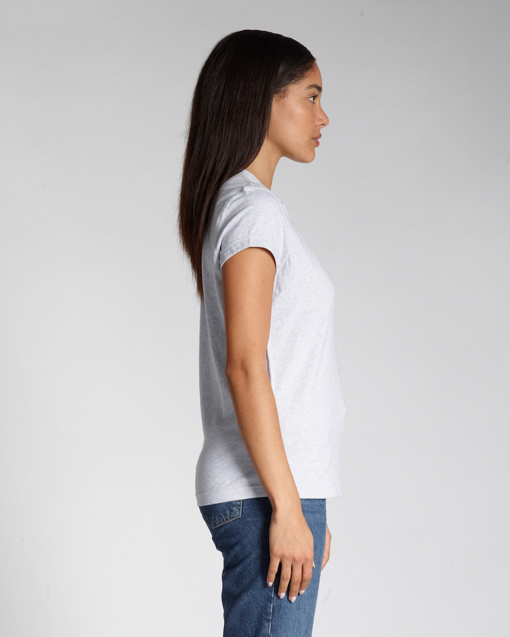 A woman facing side on, modelling a plain grey short sleeve organic cotton t shirt.