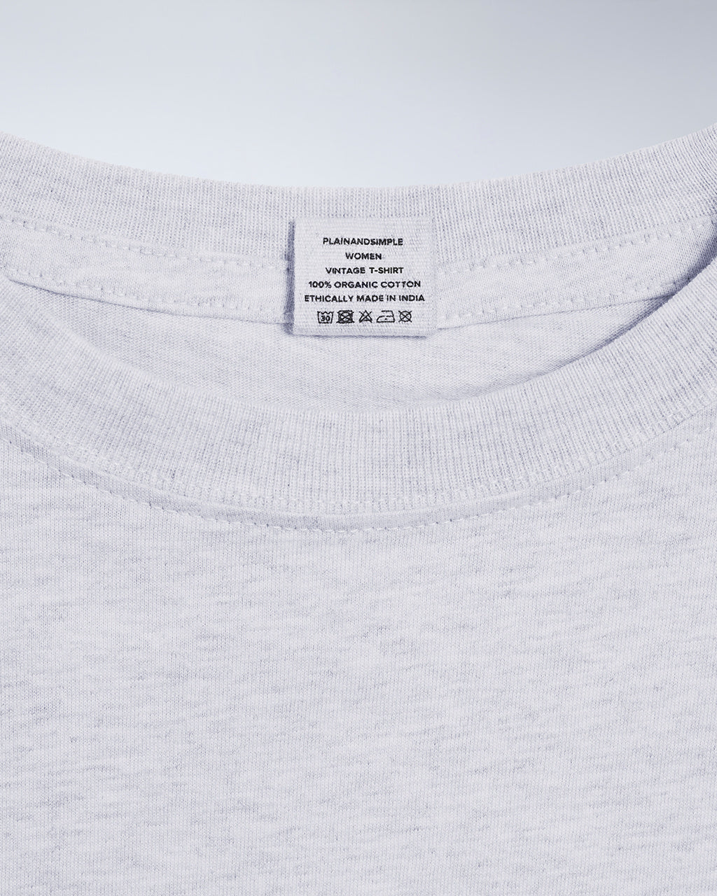 A close up of a neck label in a women's grey sleeveless crew neck organic cotton t shirt.