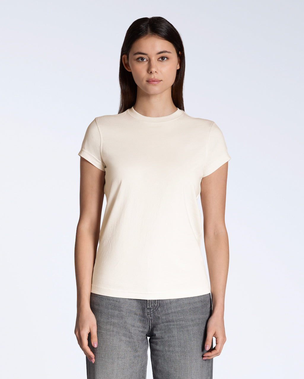 A woman facing front on, modelling a plain natural coloured, short sleeve organic cotton t shirt.