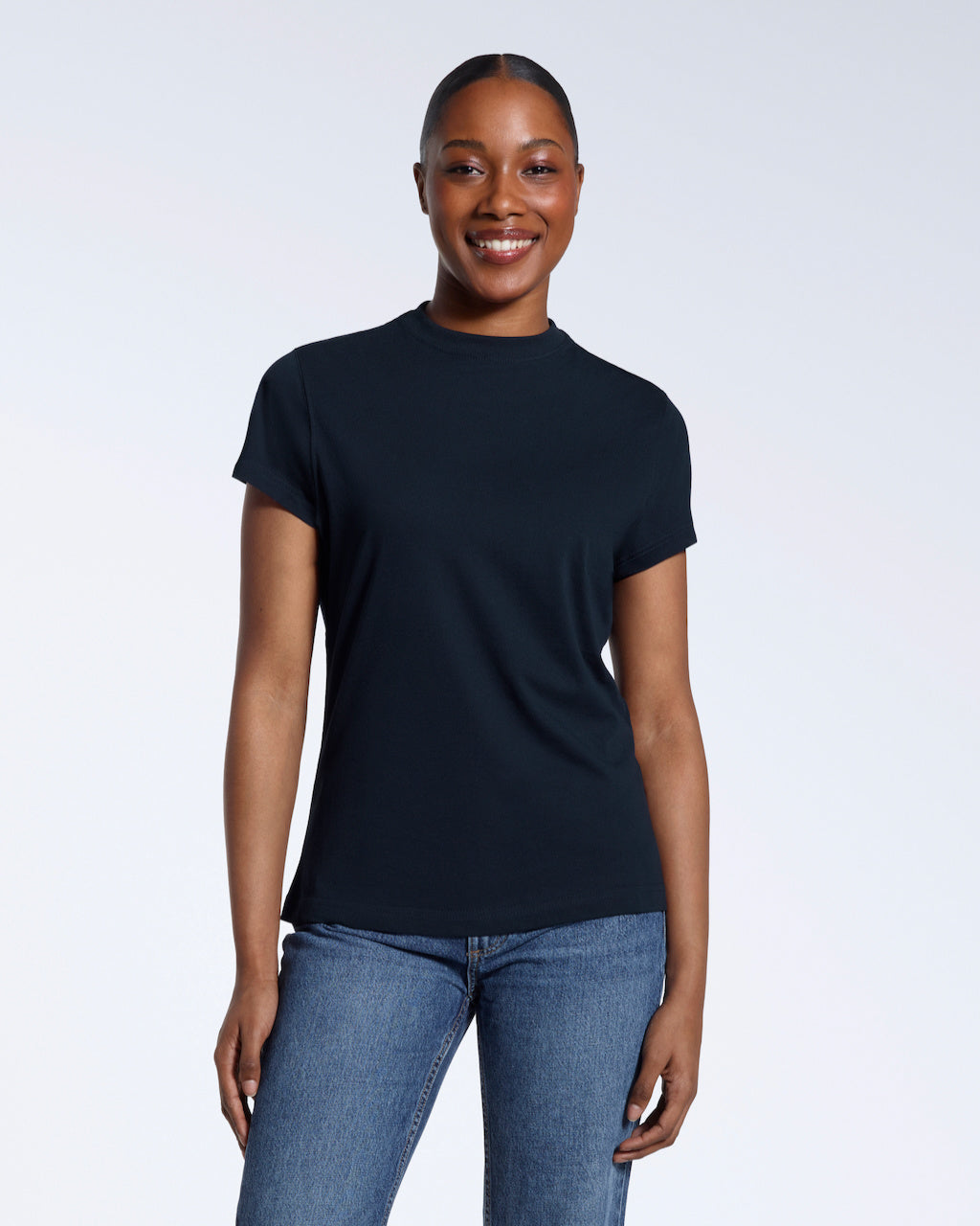 A woman facing front on smiling into the camera, modelling a plain navy short sleeve organic cotton t shirt.