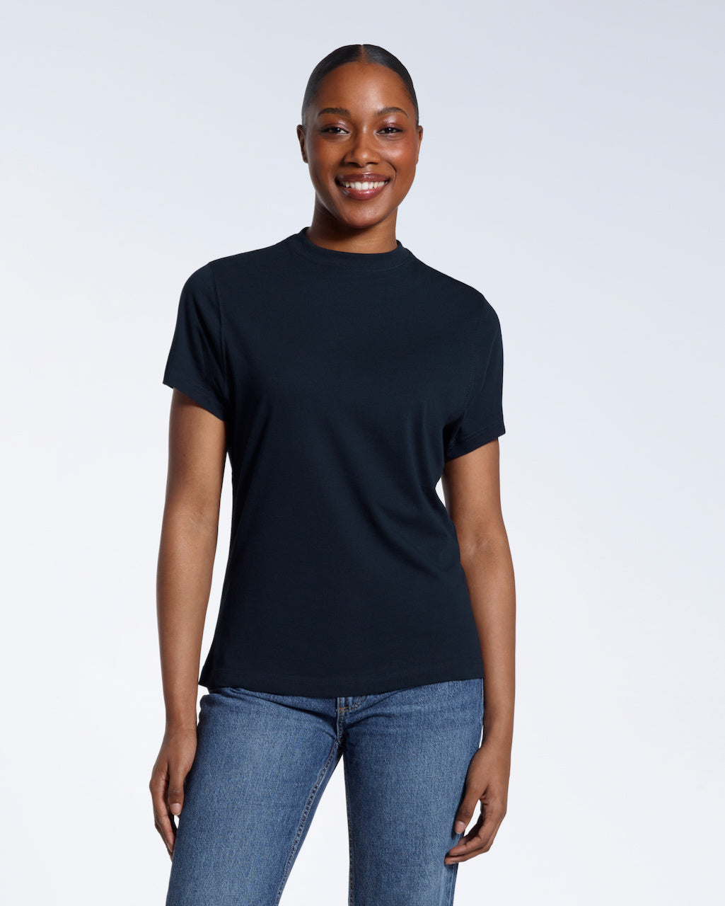 A woman facing front on smiling into the camera, modelling a plain navy short sleeve organic cotton t shirt.
