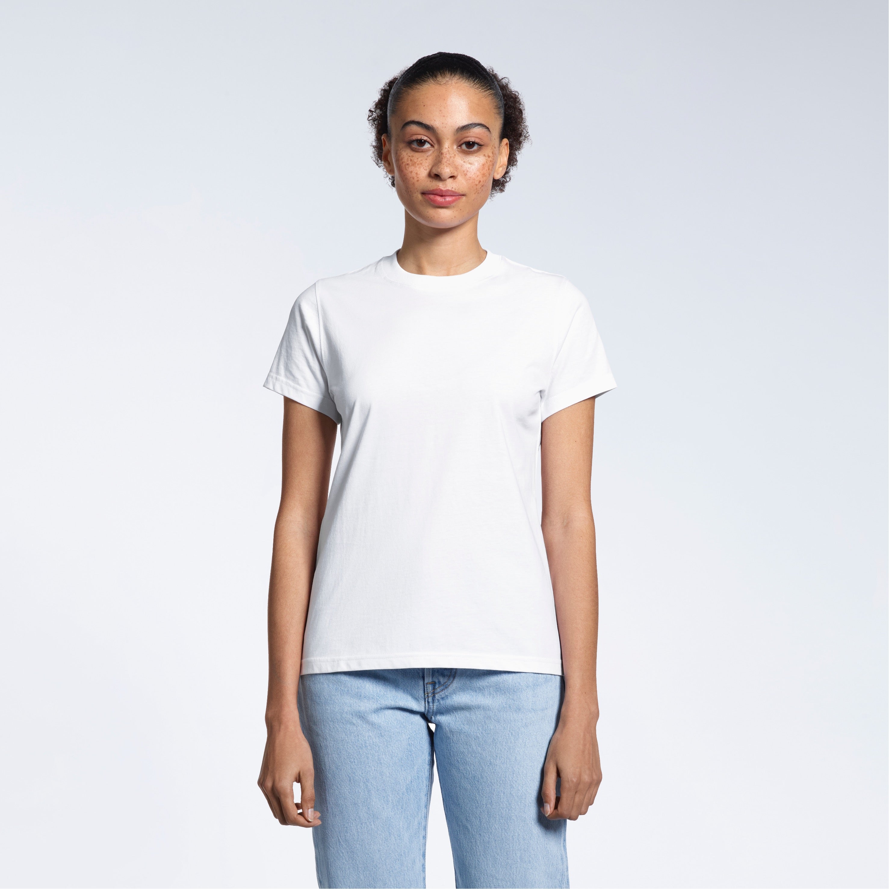A woman facing front on looking into the camera, modelling a plain white short sleeve organic cotton t shirt.