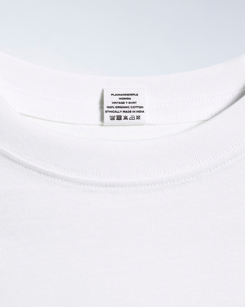 A close up of an neck label in a women's white short sleeve crew neck organic cotton t shirt.