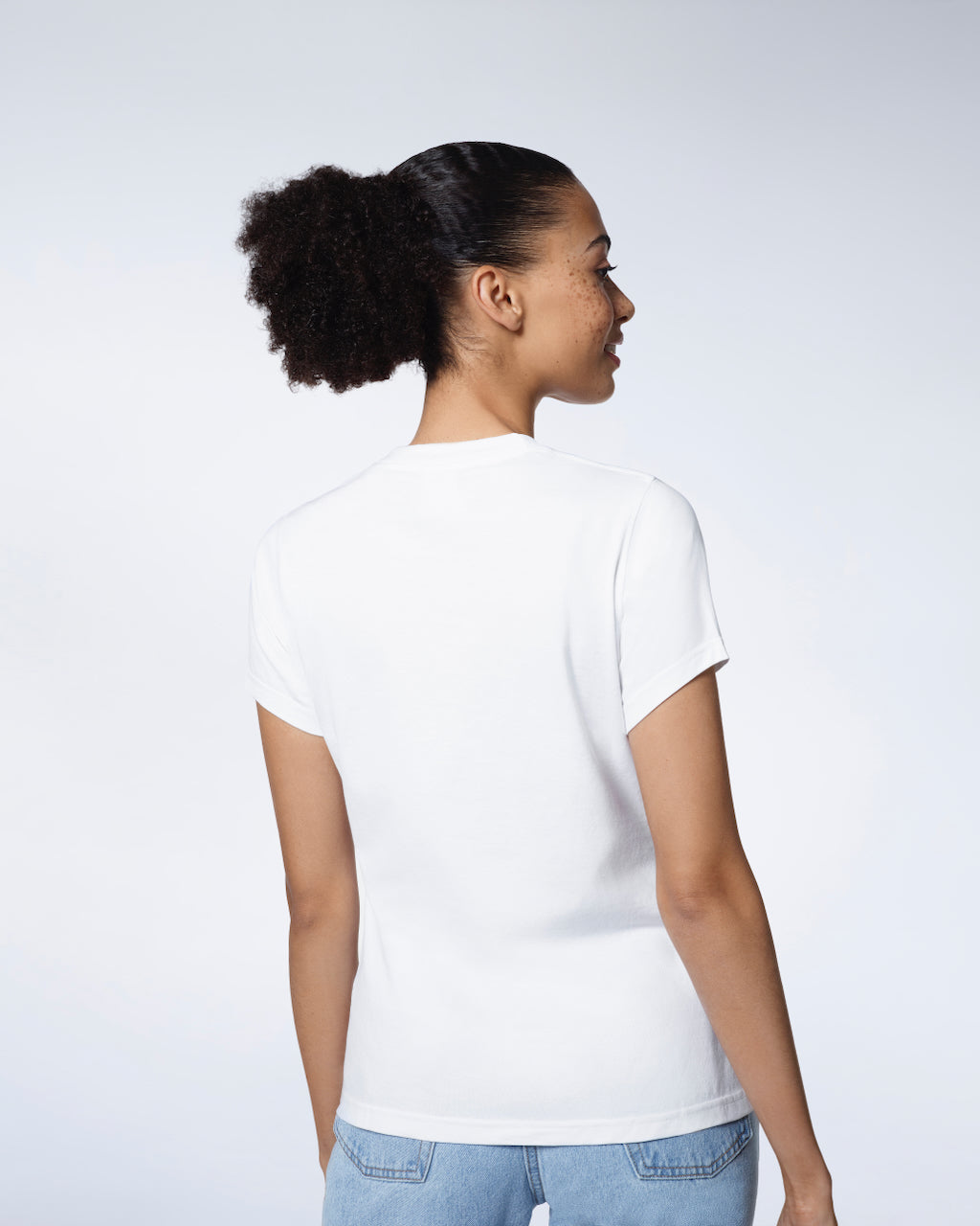 A woman facing away from the camera modelling a plain white short sleeve organic cotton t shirt.