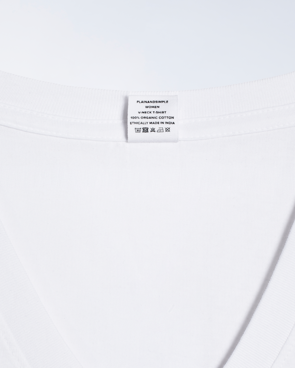 A close up of the nack label in a white, v neck, organic cotton t shirt.