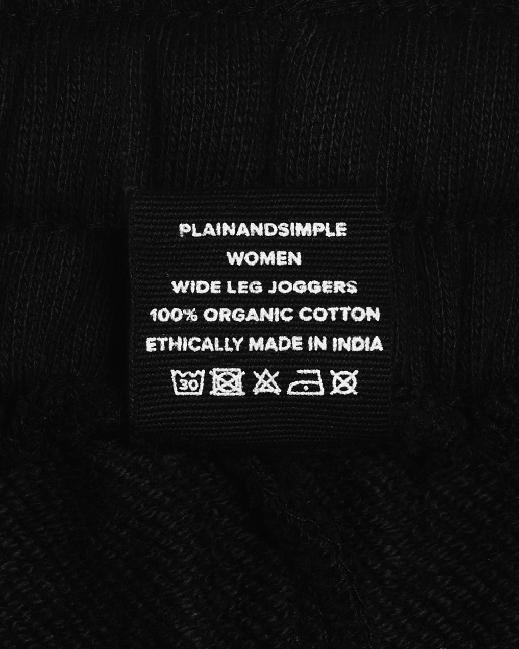 A close up of the label in a pair of black, organic cotton joggers.