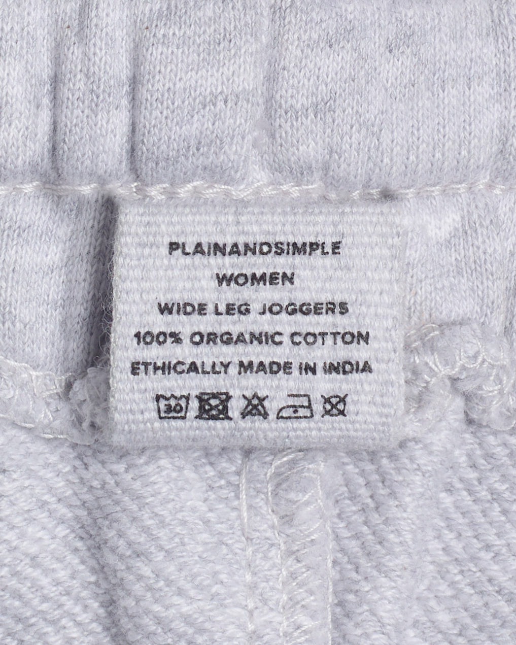 A close up of the label in a pair of grey, organic cotton joggers.