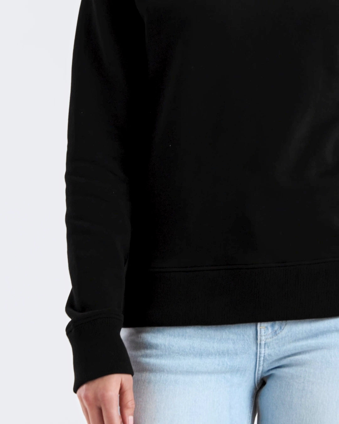 A compilation of short video clips, of a woman modelling a plain black, organic cotton sweatshirt with a pair of jeans.