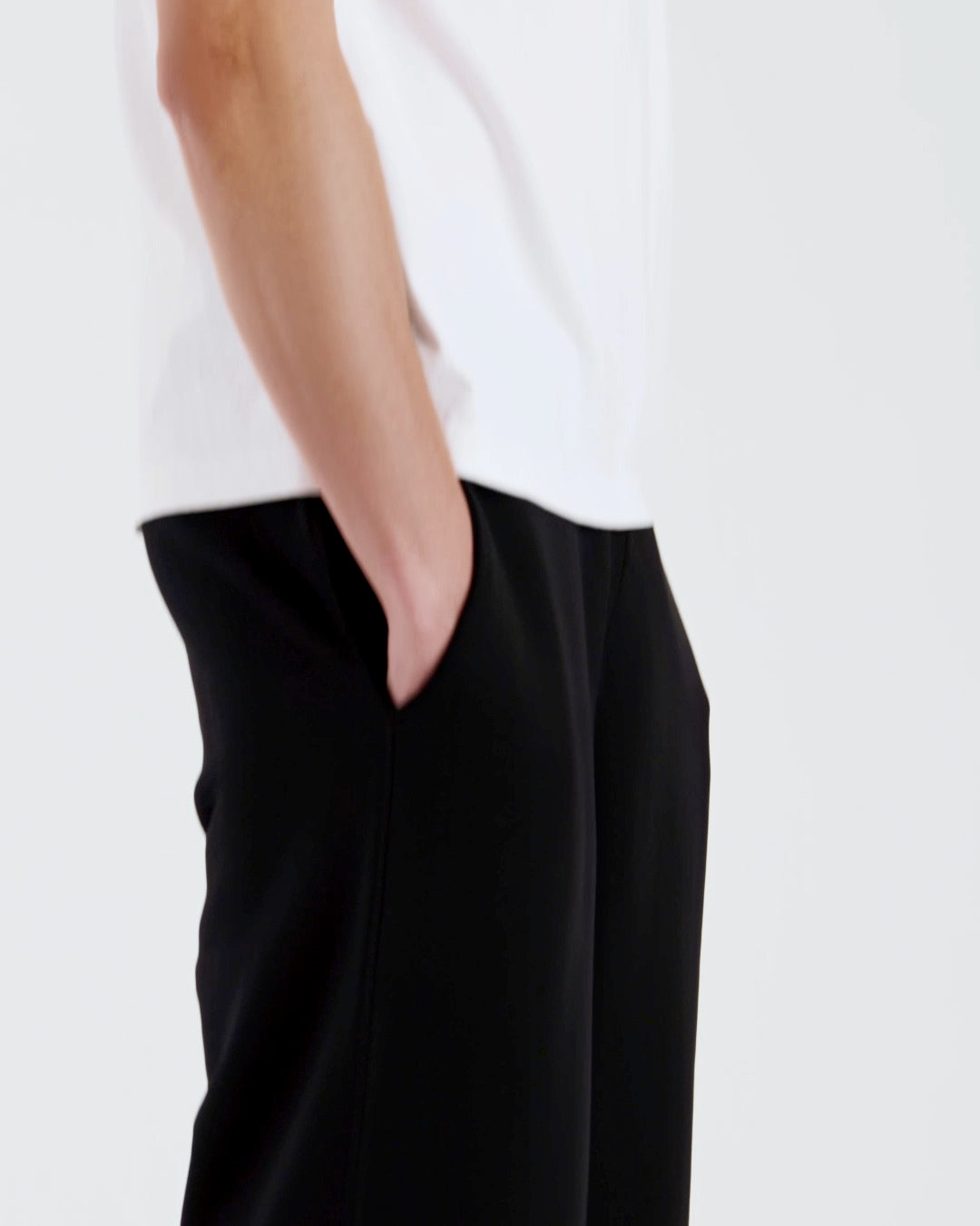 A compilation of short video clips of a man modelling plain black, organic cotton joggers with a white t shirt.
